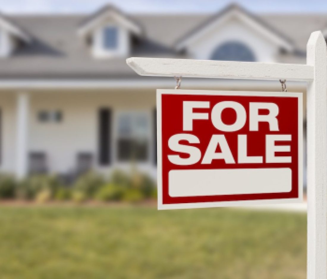 Red For Sale Real Estate Sign in Front of Beautiful New Home.